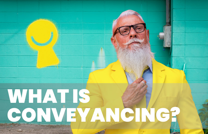 Confident older man with a long white beard wearing a bright yellow suit, standing in front of a turquoise wall with a yellow Keyo, the Titlespace mascot, sprayed on it. White overlay text reads “What Is Conveyancing?